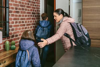 Family with emergency backpacks leaving their front door quickly due to an emergency evacuation